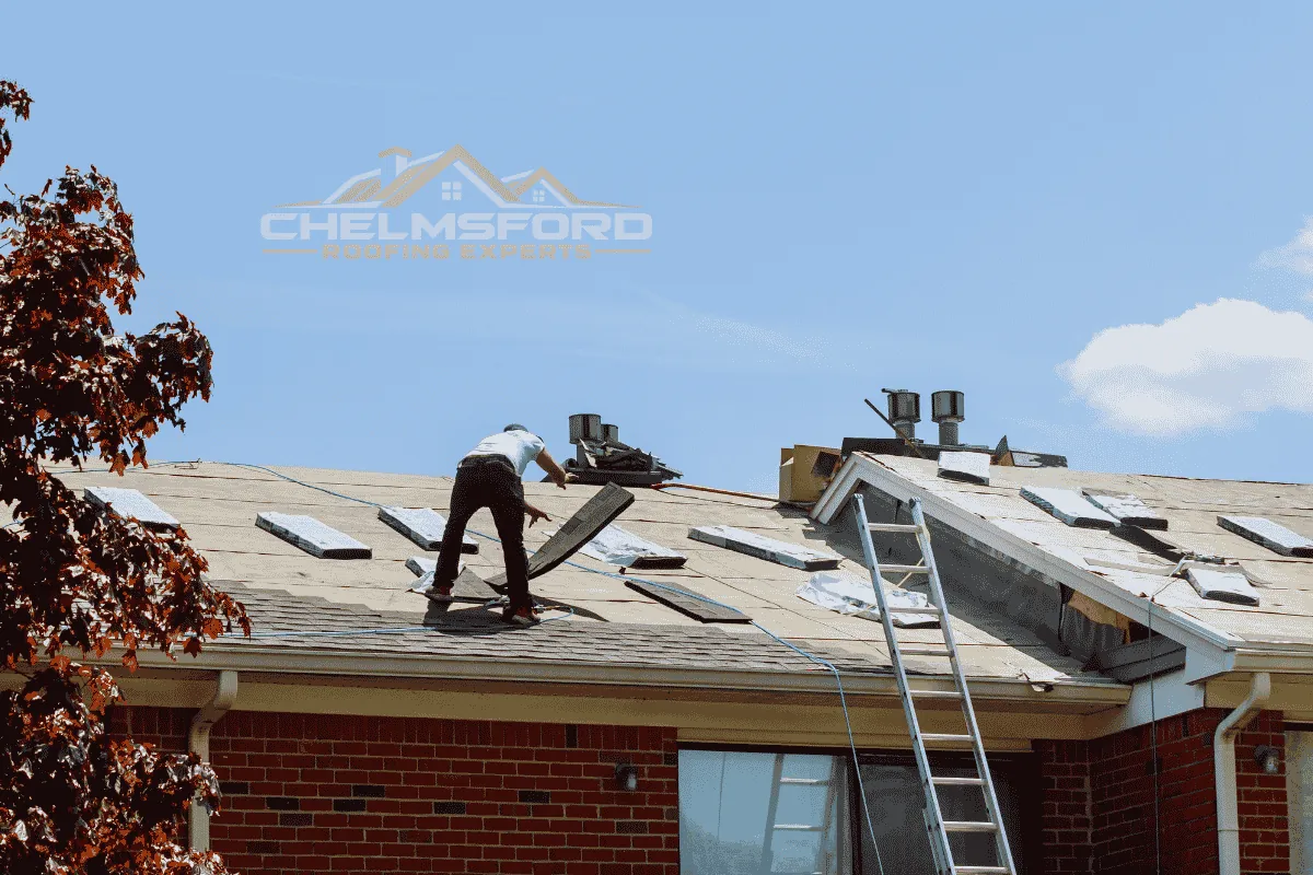 Roofer working on exposed roof decking during a roof replacement