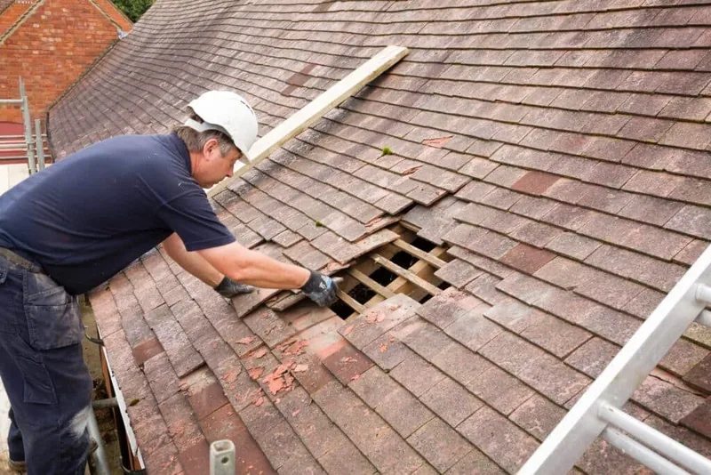 Illustrative roofer lifting interlocking tiles to expose timber battens - epdm vs grp vs felt flat roofing roofing guidance for Chelmsford, Essex